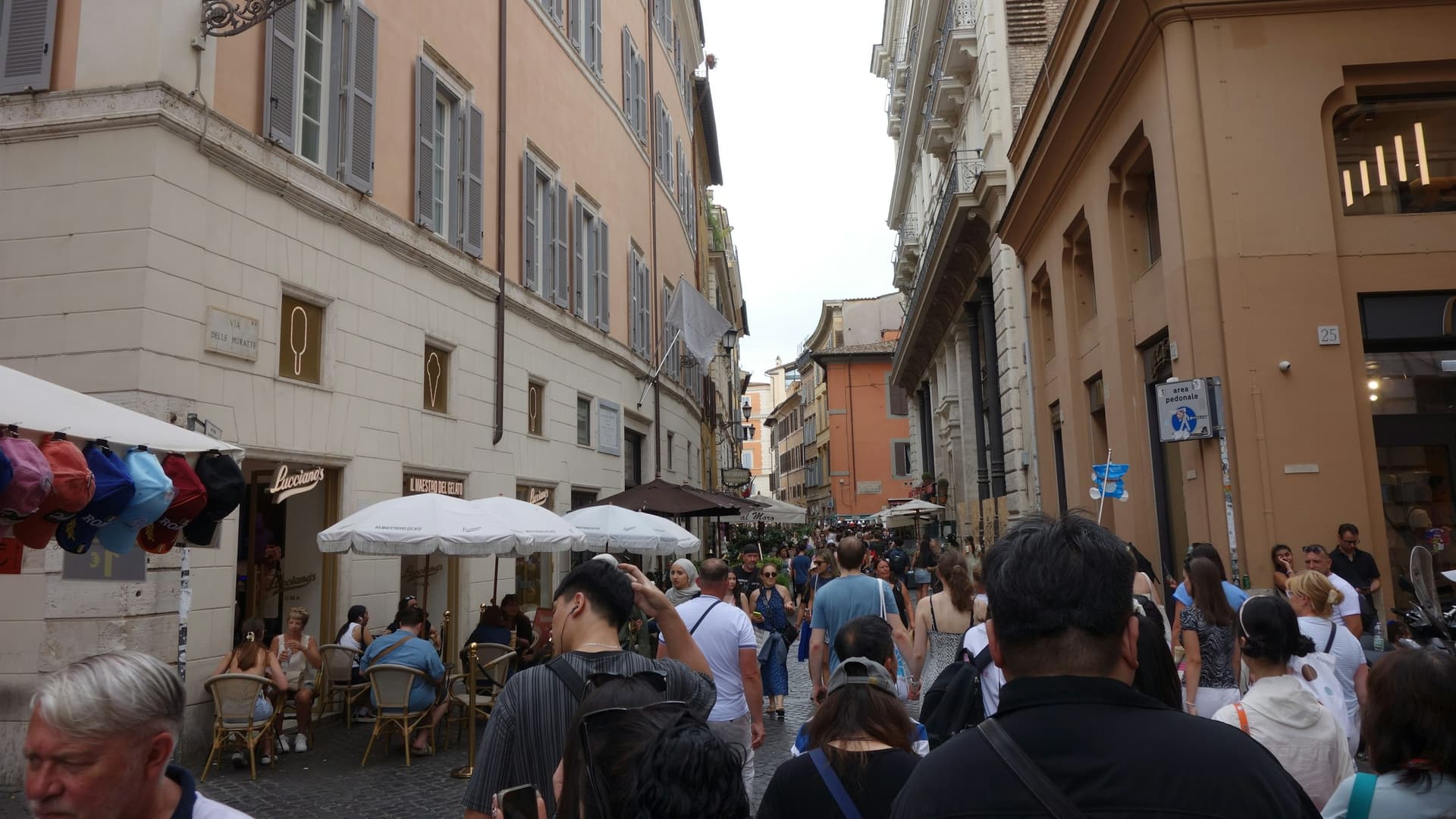 Multitud de turistas caminando por una calle estrecha del centro de Roma