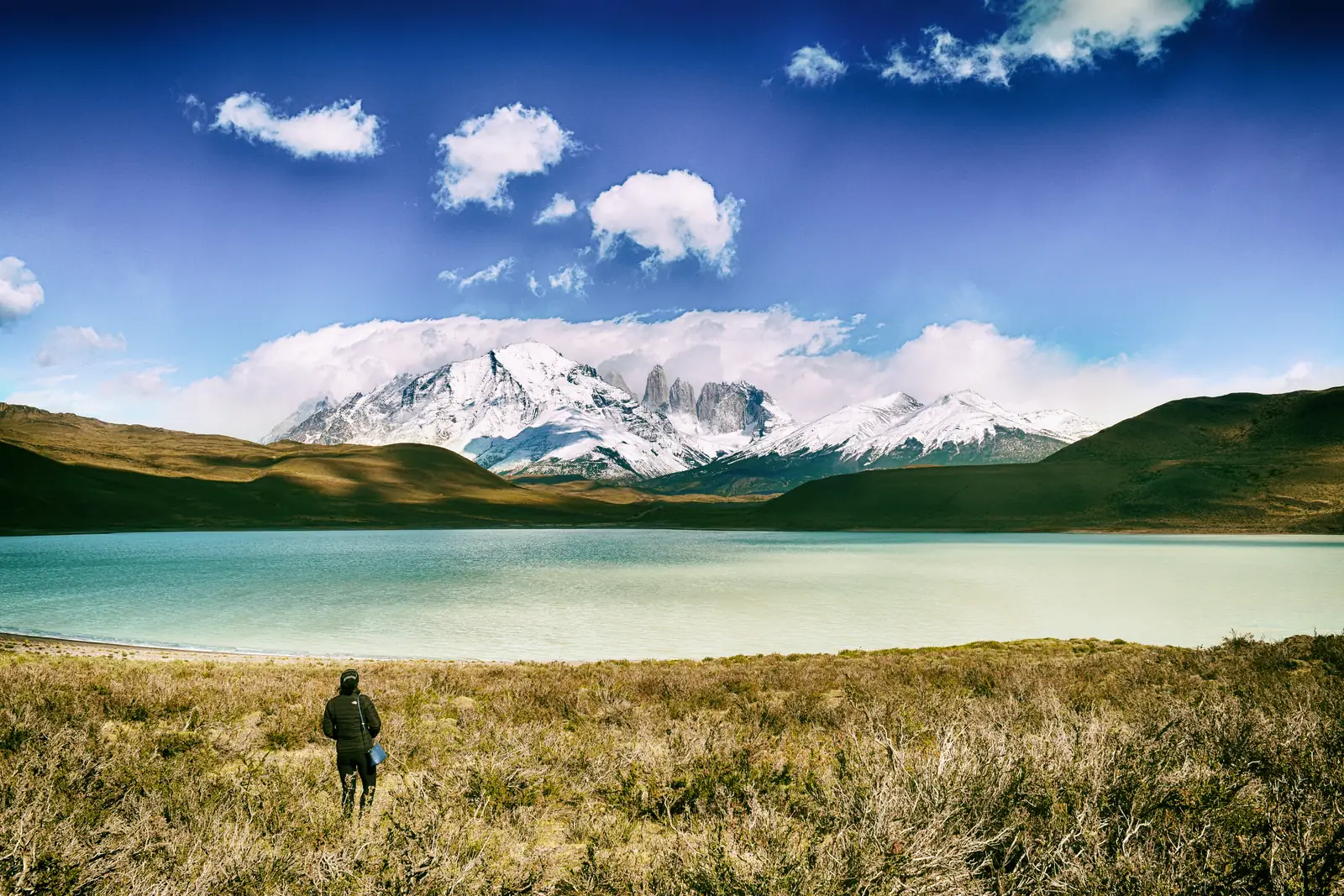 Excursionista frente a un lago y las montañas del Parque Nacional Torres del Paine, en la Patagonia chilena